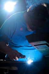 Semi professional welder welding a piece of metal