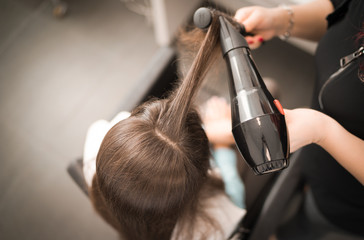 Fototapeta na wymiar Detail of drying hair with hair dryer and brush.