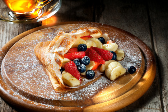 view of nice fresh hot crepes with berries   on color background