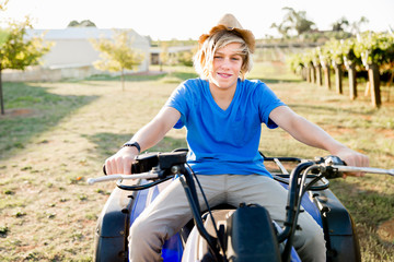 Obraz premium Boy riding farm truck in vineyard