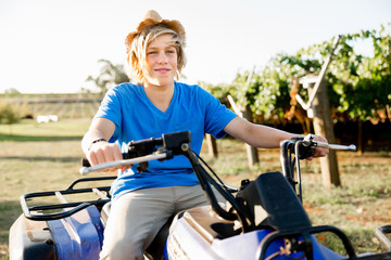 Boy riding farm truck in vineyard
