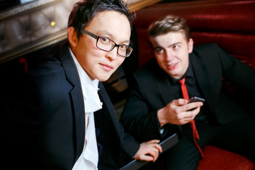 Two stylish man talking, dressed suits and ties, informal atmosphere at bar, men's friendship.