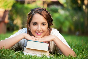 girl resting on top of books