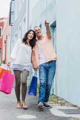 Man pointing woman with shopping bags