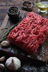 Closeup of raw fresh ground meat and condiments, selective focus