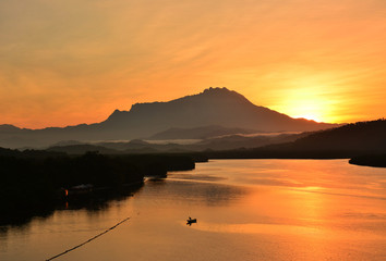 Sunrise moment. View of Mount Kinabalu in the far horizon seen from the Jetty Mengkabong, Sabah Borneo, Malaysia.