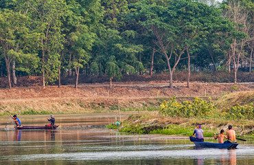 Fototapeta premium The fisherman in the boat use net to catch fish in the river.
