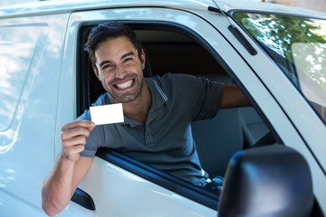 Handsome driver with toothy smiling showing blank card