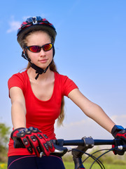 Portrait of bikes cycling girl. Girl rides bicycle at blue sky. Girl in cycling. Cycling is good for health. Cyclist posing at camera.