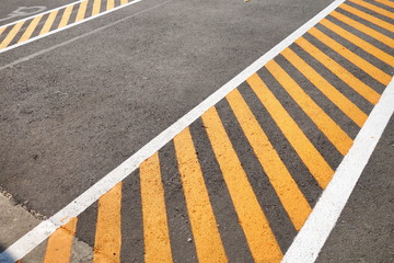 Black asphalt pavement painted with yellow stripes