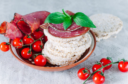 rice cakes with sausage, basil and cherry tomatoes