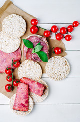 rice cakes with sausage, basil and cherry tomatoes