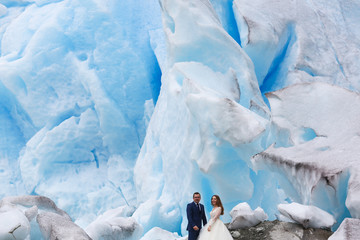  bride and groom  posing near glacier