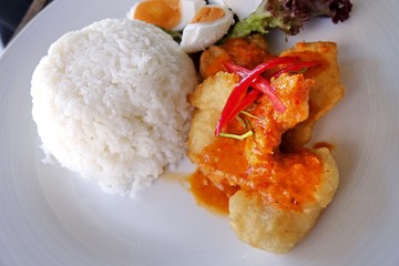 Fried fish with spicy curry sauce and rice.