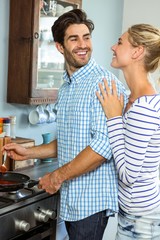 Young couple preparing food together in kitchen