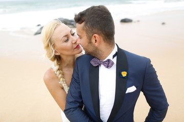 bride and groom posing on the beach