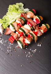 Preparing food for cooking barbecue on skewers on black stone