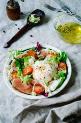 Summer salad with mozzarella, cherry tomatoes, lettuce and prosciutto