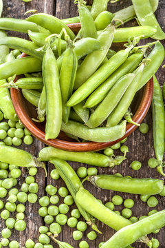 freshly picked organic peas on a rustic wooden table