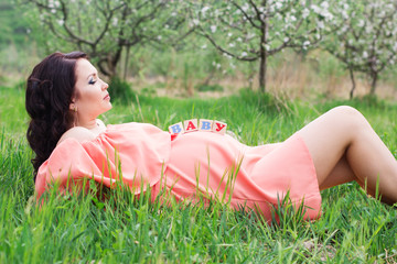 Pregnant girl with babies wooden bricks on her belly