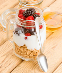 transparent jar with berries and yogurt cereals