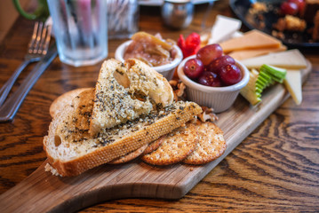 Bread, cheese, cracker, and fruit platter on a wooden board
