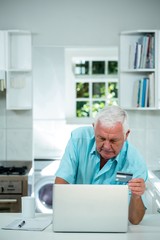 Fototapeta premium Senior man doing online shopping by using laptop
