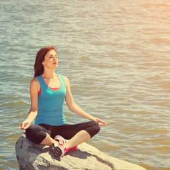 Fototapeta na wymiar woman meditating on the sea shore
