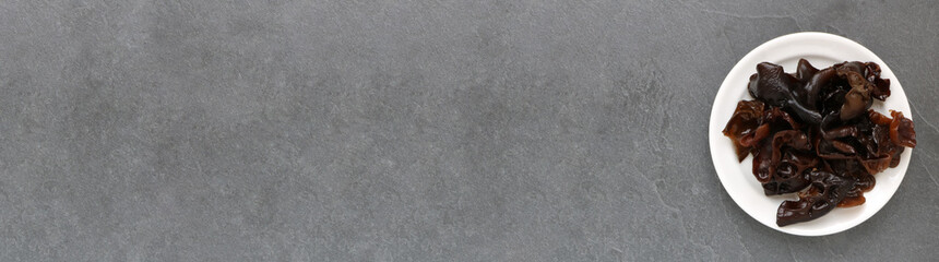 Champignon noir / Oreille de Judas dans une assiette sur ardoise... bannière 