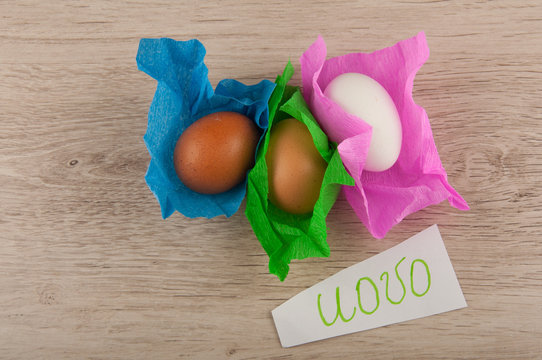 top view title and chicken eggs in paper laying on wooden table