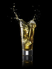 Splash in alcoholic drink on black background