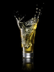 Splash in alcoholic drink on black background