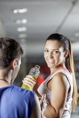 woman drinking energy drink at the gym