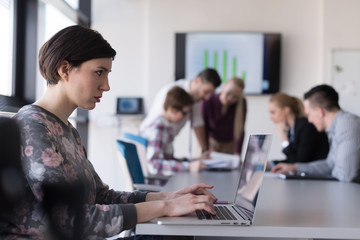 young business woman at office working on laptop with team on me