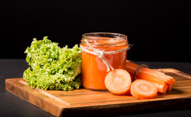 Fresh carrot smoothie in the glass on black stone. Refresh juice drink. Lifestyle concep