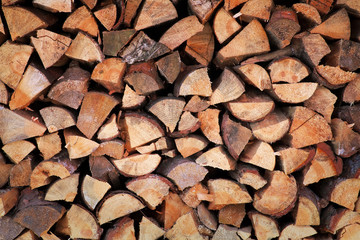 Background of chopped firewood stacked up on top of each other 