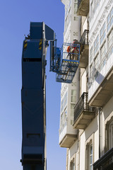 construction  workers in bucket of  crane vehicle for restore the old  building
