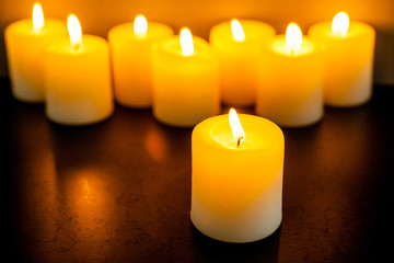 closeup to burning candles in darkness