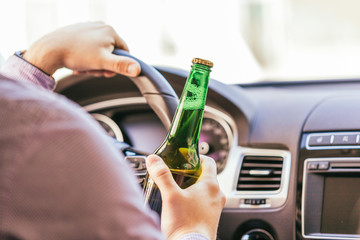 man drinking alcohol while driving the car