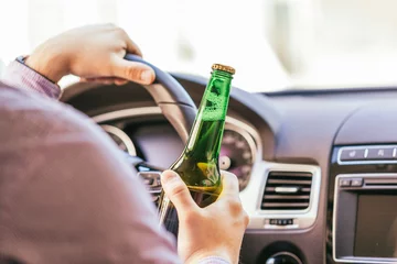 Foto op Plexiglas man drinking alcohol while driving the car © fotofabrika
