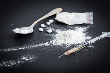 Drug syringe and cooked heroin on spoon