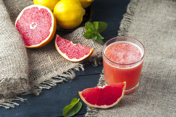 Glass of freshly squeezed grapefruit juice on wooden table. Drink for dieting. Focus on glass.