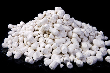 Kaolin. Pile of white chalks on the black background 