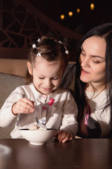 mother and her small daughter in a cafe