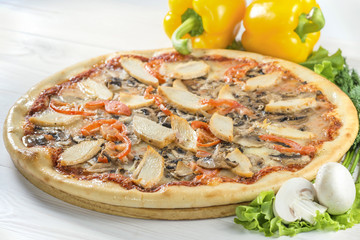 tasty pizza on a wooden board with pepper and mushrooms