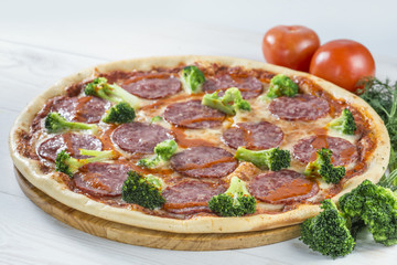 tasty pizza on a wooden board with red pepper and mushrooms