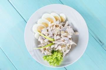 meat salad with egg on the wooden background
