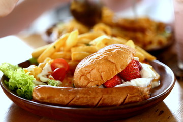Fruit Burger, Sausage and Fries Being Served on Plate