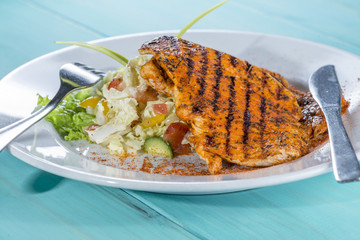 chicken grilled with fresh salad mix on the painted wooden backg