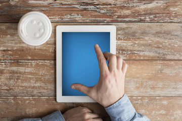 close up of male hands with tablet pc and coffee